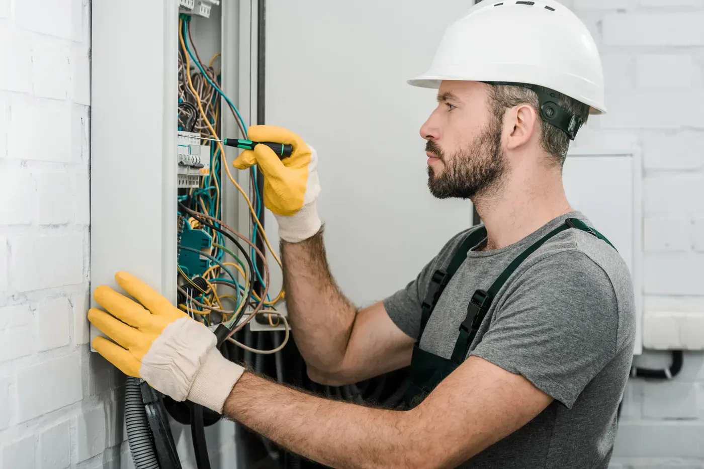 Électricien raccordant une borne Green'up sur un tableau divisionnaire dans un pavillon de Montfermeil